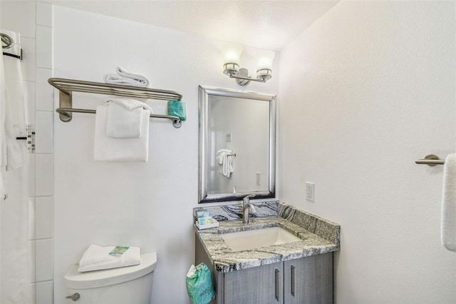 bathroom featuring vanity, a textured ceiling, and toilet