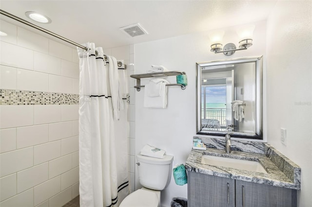 bathroom with a shower with shower curtain, vanity, and toilet