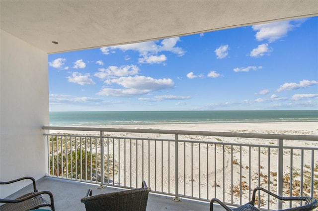 balcony with a water view and a beach view