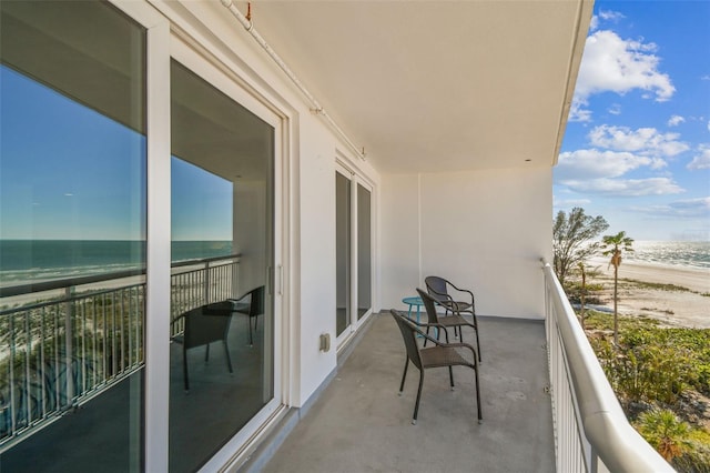 balcony with a water view and a beach view