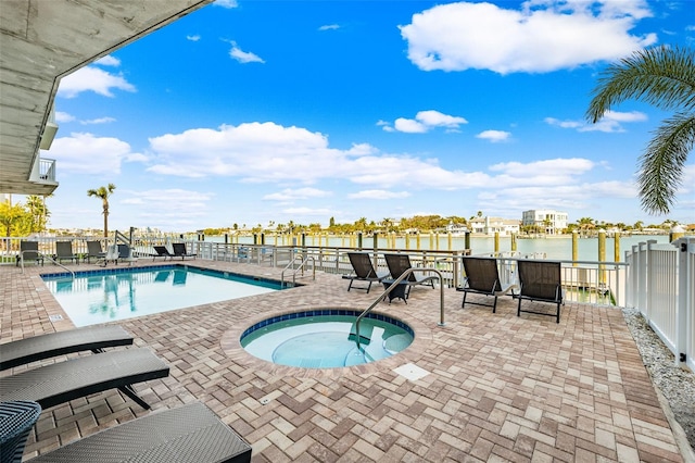 view of swimming pool with a community hot tub, a patio, and a water view