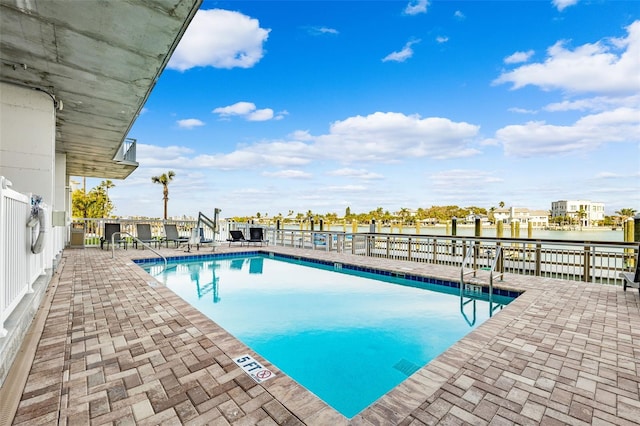 view of swimming pool with a water view and a patio