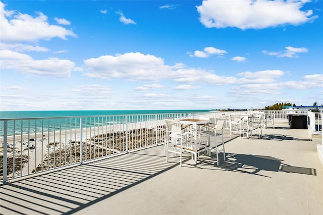 view of patio / terrace featuring a water view and a view of the beach