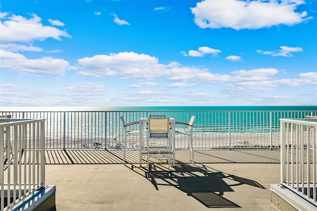 view of patio / terrace with a water view and a beach view