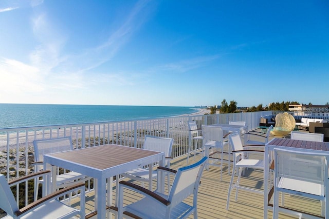 wooden terrace featuring a water view and a beach view