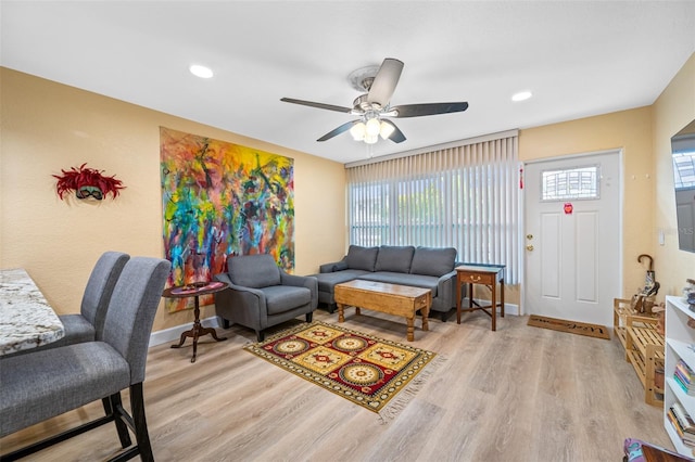 living room with light wood-type flooring and ceiling fan