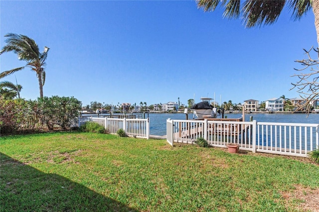 view of yard with a water view and a dock