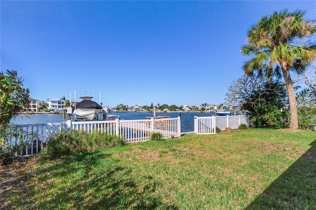 view of yard with a water view and a dock