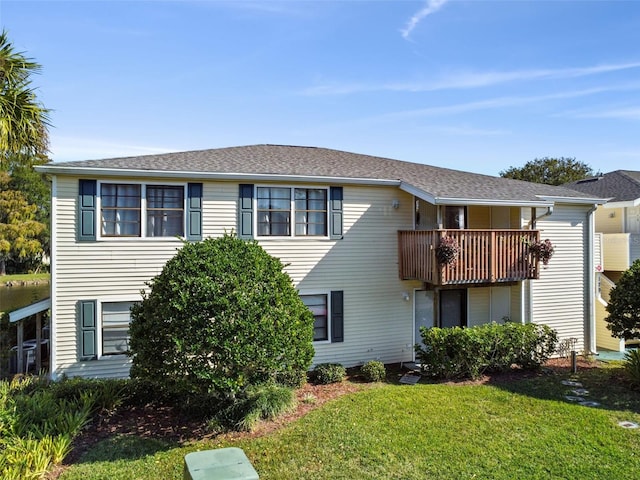 view of front of property with a balcony and a front lawn