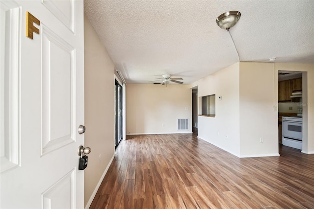 unfurnished living room with ceiling fan, a textured ceiling, and hardwood / wood-style flooring