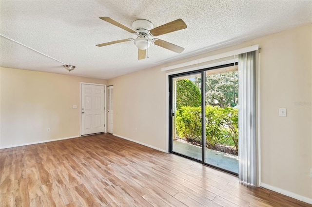 unfurnished room with ceiling fan, a textured ceiling, and light wood-type flooring