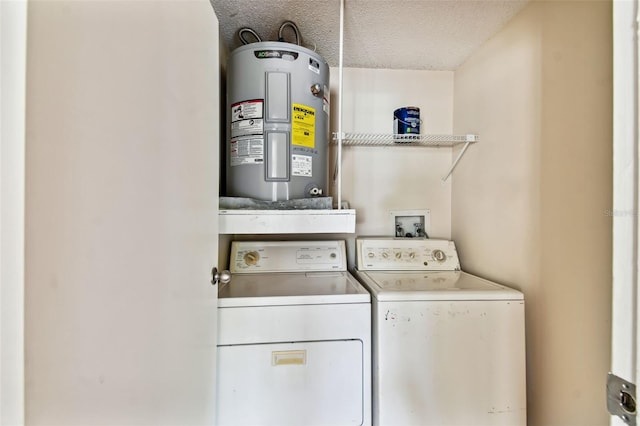 laundry area featuring water heater, washer and clothes dryer, and a textured ceiling