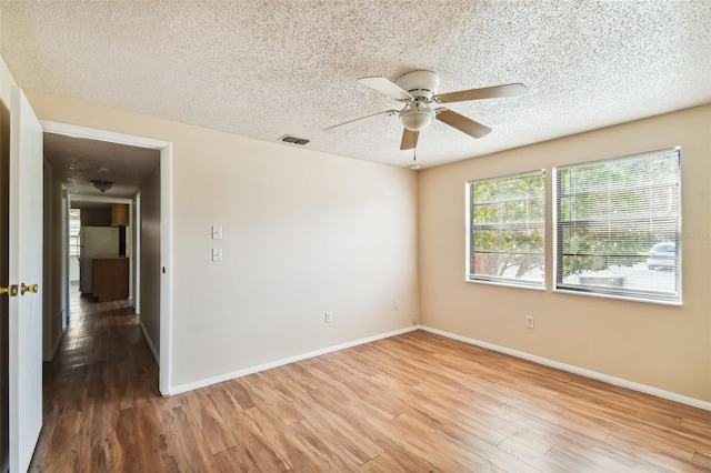 spare room featuring wood-type flooring, a textured ceiling, and ceiling fan