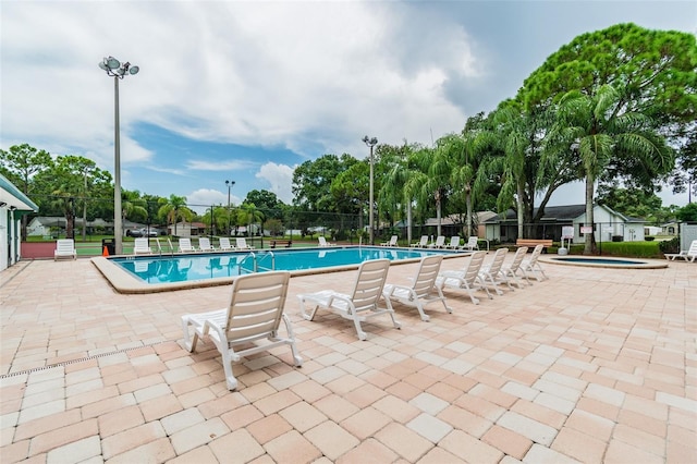 view of swimming pool featuring a patio area and a community hot tub