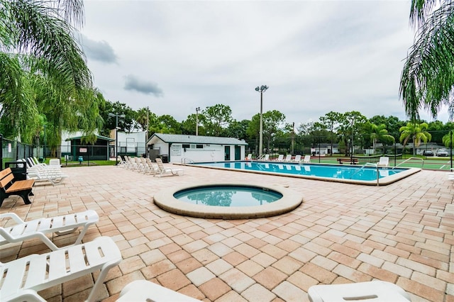 view of swimming pool featuring a patio area and a hot tub