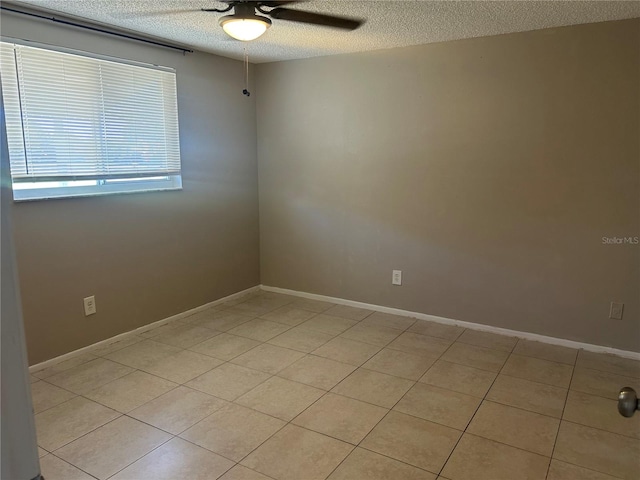 tiled empty room featuring a textured ceiling and ceiling fan