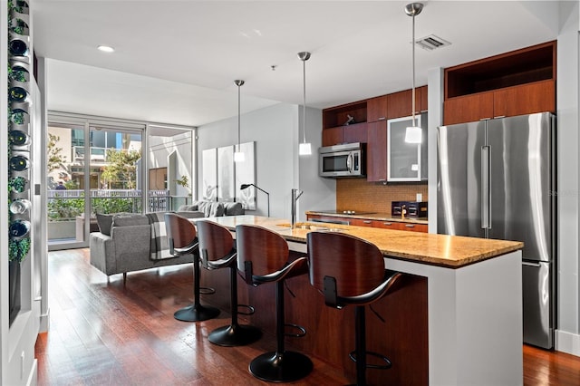 kitchen featuring pendant lighting, a breakfast bar, dark hardwood / wood-style floors, and stainless steel appliances