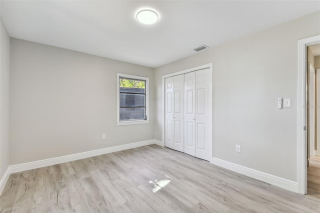 unfurnished bedroom featuring light wood-type flooring and a closet