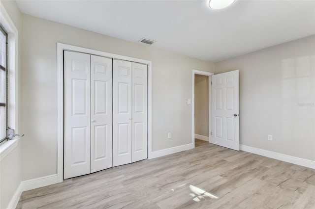 unfurnished bedroom with a closet and light hardwood / wood-style flooring