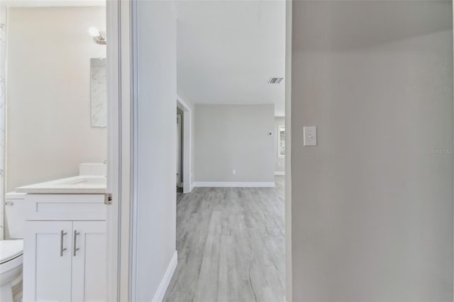 hallway with light hardwood / wood-style floors