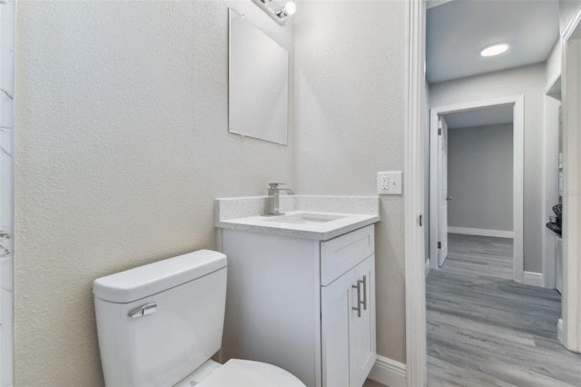 bathroom featuring hardwood / wood-style floors, vanity, and toilet