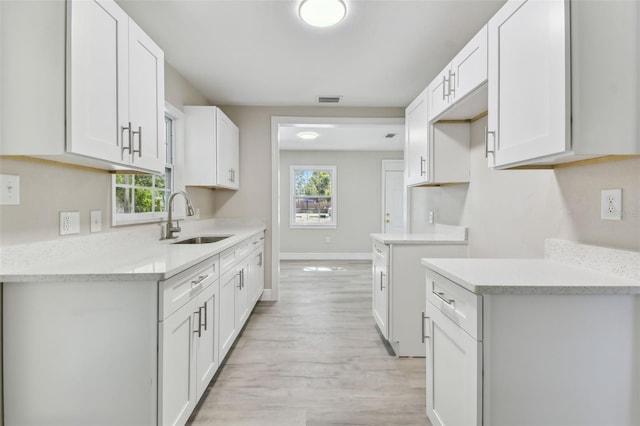 kitchen featuring white cabinets, sink, and a wealth of natural light