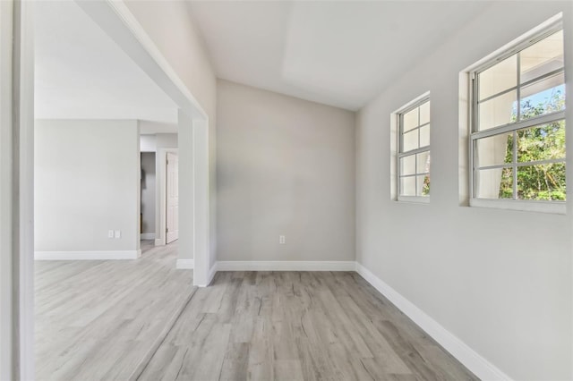 unfurnished room featuring light hardwood / wood-style floors and vaulted ceiling