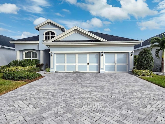34 Concord Dr, Dunedin, FL 34698 - view of front of home with decorative driveway, an attached garage, and stucco siding