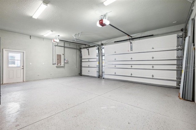 garage with a garage door opener and electric panel