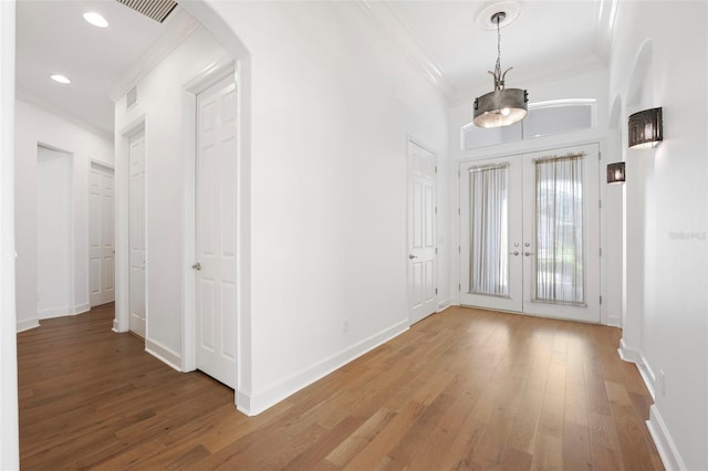 34 Concord Dr, Dunedin, FL 34698 - foyer featuring ornamental molding, arched walkways, wood finished floors, french doors, and recessed lighting