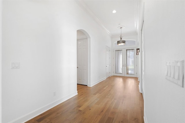 34 Concord Dr, Dunedin, FL 34698 - hallway with crown molding, baseboards, arched walkways, wood finished floors, and recessed lighting
