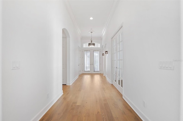 34 Concord Dr, Dunedin, FL 34698 - corridor featuring french doors, arched walkways, crown molding, baseboards, and light wood finished floors
