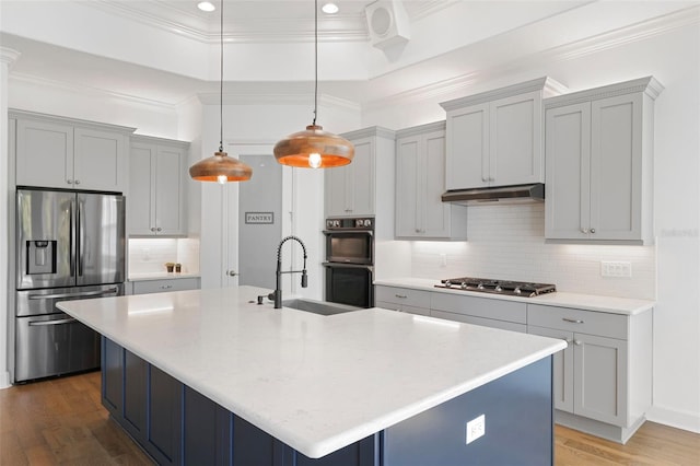 34 Concord Dr, Dunedin, FL 34698 - kitchen with appliances with stainless steel finishes, a sink, wood finished floors, crown molding, and decorative backsplash
