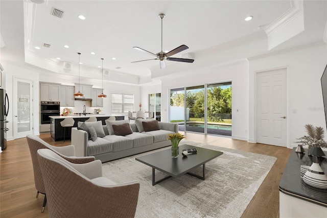 34 Concord Dr, Dunedin, FL 34698 - living area featuring a raised ceiling, crown molding, ceiling fan, wood finished floors, and recessed lighting
