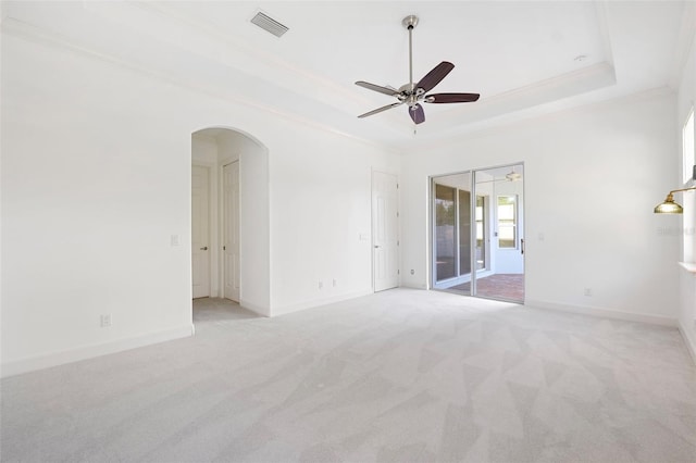 34 Concord Dr, Dunedin, FL 34698 - unfurnished room featuring a raised ceiling, crown molding, ceiling fan, arched walkways, and light carpet