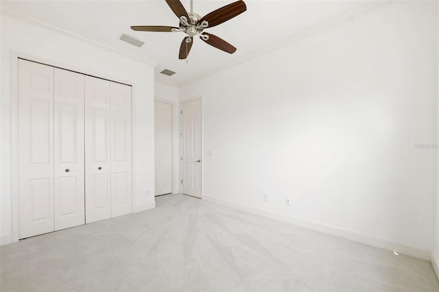 34 Concord Dr, Dunedin, FL 34698 - unfurnished bedroom featuring crown molding, light carpet, a closet, baseboards, and a ceiling fan