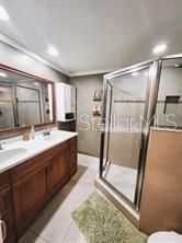 bathroom with tile patterned floors, vanity, an enclosed shower, and toilet