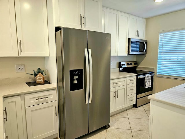 kitchen featuring white cabinets, stainless steel appliances, and light tile patterned floors