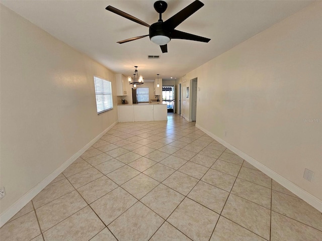 unfurnished living room featuring ceiling fan with notable chandelier and light tile patterned floors