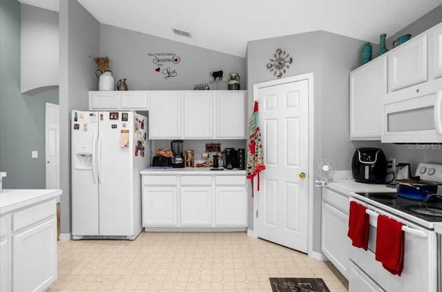 kitchen with vaulted ceiling, white cabinetry, and white appliances