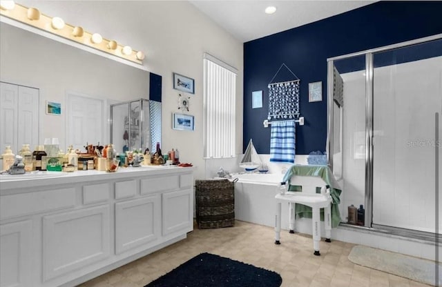 bathroom with vanity and shower with separate bathtub