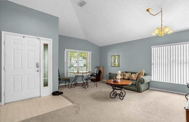 carpeted entrance foyer with a chandelier, a textured ceiling, and lofted ceiling