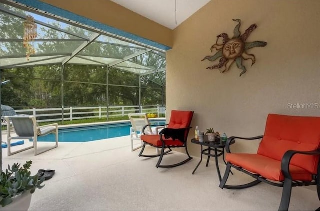 view of swimming pool featuring a patio and a lanai