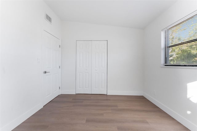 unfurnished bedroom with hardwood / wood-style flooring and a closet