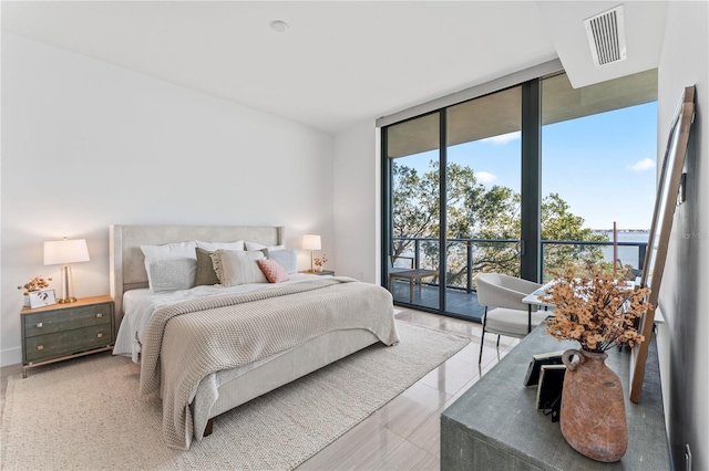 bedroom featuring light tile patterned floors, access to outside, and expansive windows