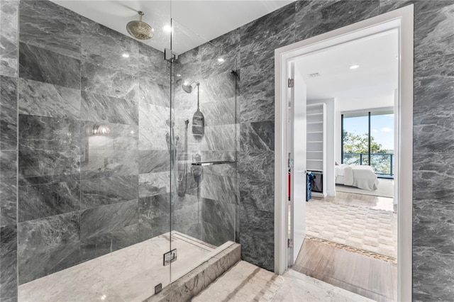 bathroom with an enclosed shower and tile walls