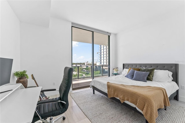 bedroom with light hardwood / wood-style flooring and expansive windows