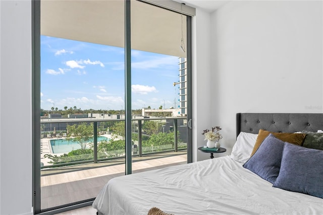 bedroom with expansive windows and wood-type flooring