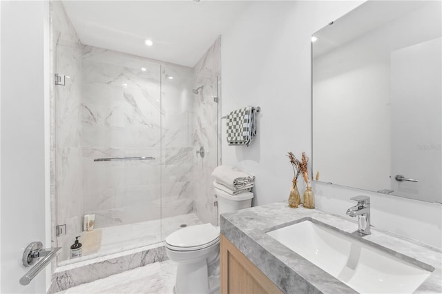 bathroom with a shower with door, vanity, and toilet