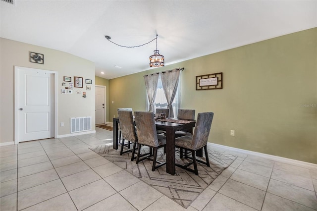 dining room featuring light tile patterned floors, vaulted ceiling, and a notable chandelier